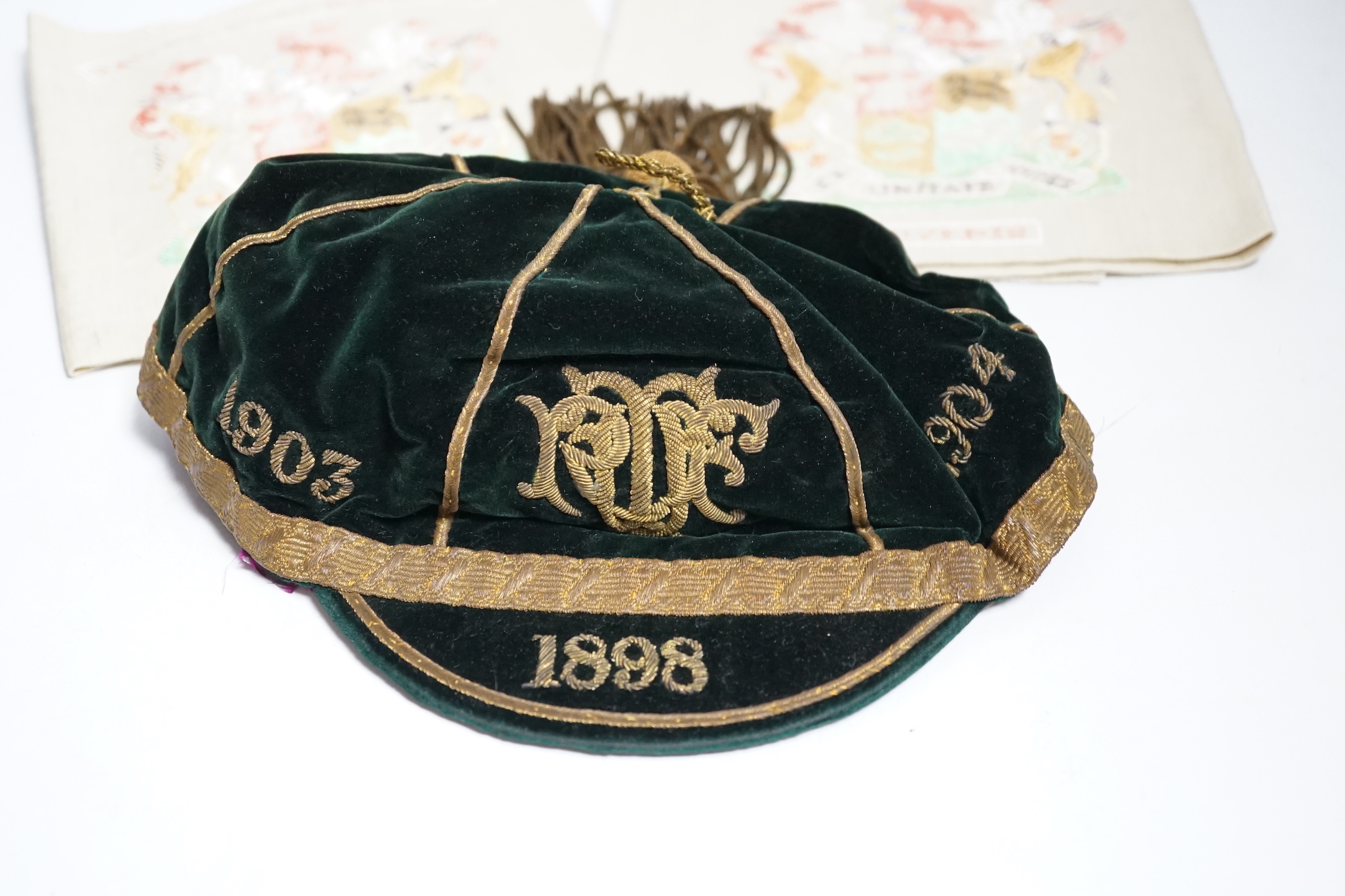 Two South African late 19th century damask railway napkins and a velvet rugby or cricketing cap